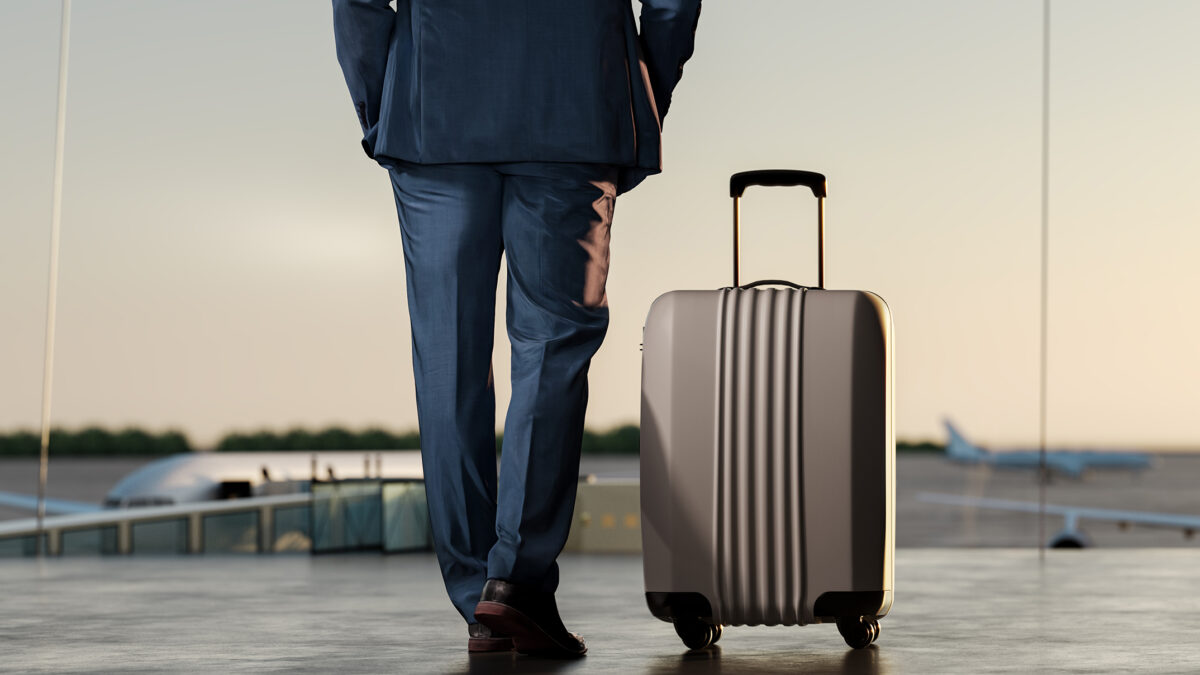 Travel concept background. Businessman with suitcase at airport